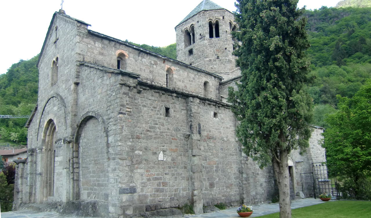 Il fianco meridionale della chiesa di San Salvatore a Capo di Ponte, in pietra a vista, con absidi e campanile romanici.