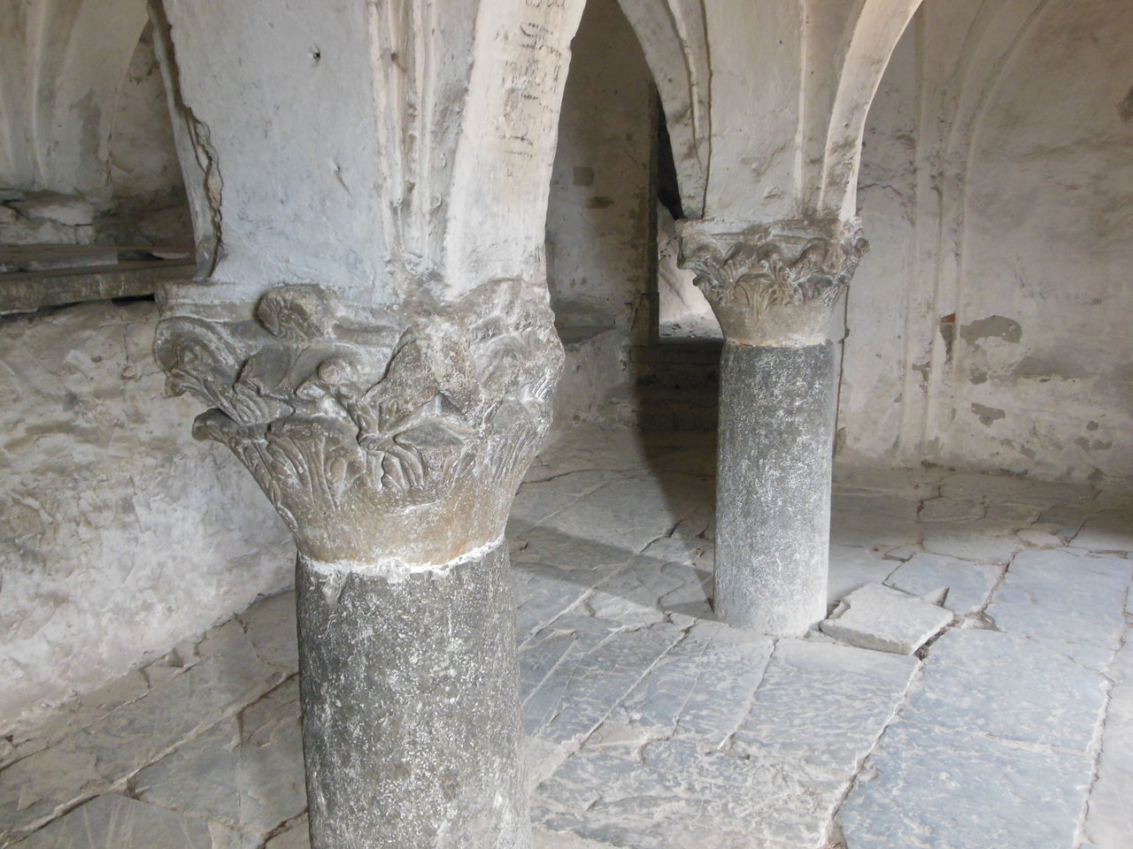 La cripta della pieve di San Siro a Cemmo: colonne tozze in pietra con capitelli scolpiti che reggono volte basse.